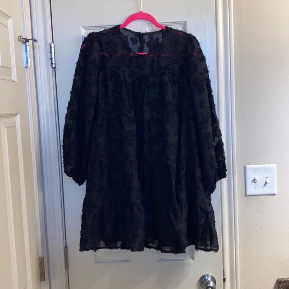 Black dress with floral appliqué. Lined. Sleeves. Flowy.